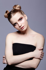 Young teen female beauty portrait with day makeup and bun hair style