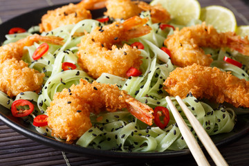 Japanese cuisine: tempura shrimp with green noodles, chili, lime and sesame close-up. horizontal