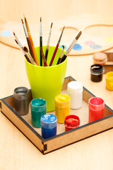 Motley paints and brushes in a cup ready for painting