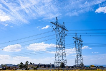 High voltage power transmission tower on blue sky background,  electricity distribution.