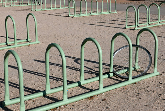 Blassgrüner Fahrradständer mit einem angeschlossenen Vorderrad