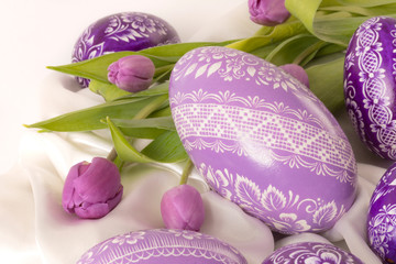 purple eastern egg on white cloth with purple tulip