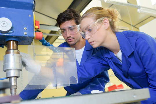 Man And Lady Using Industrial Drill