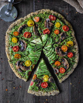 Overhead view of pesto pizza on table