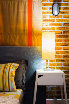 lamp on night table next to bed, cozy living. bedroom interior