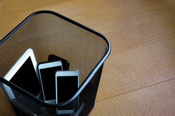 Smartphones in trash bin with copy space