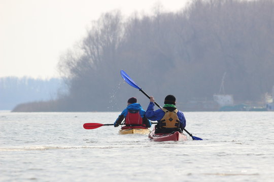 Two Guys In Kayaks In Winter Danube River. Winter Kayaking