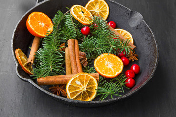Obraz na płótnie Canvas Christmas spices.Anise, cranberries,fir tree branches,orange slices, cinnamon sticks on a pan