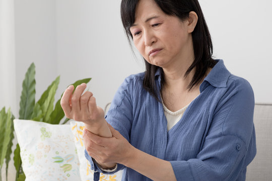 腕を気にする女性、痺れ、痛み、麻痺