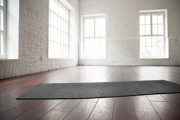 Empty white space in fitness center, white brick walls, natural wooden floor and big windows,...