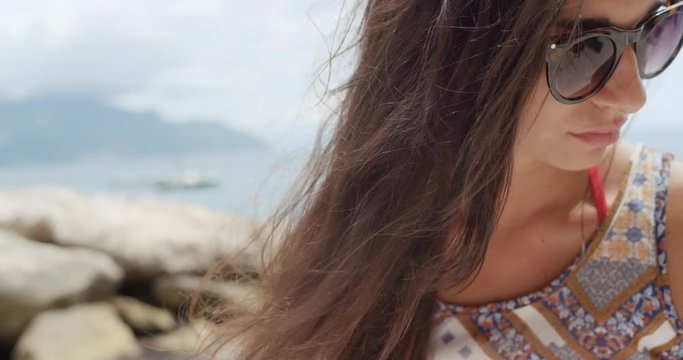 Close up portrait of Beautiful Young Woman hair blowing in wind wearing bohemian hippie dress on tropical beach slow motion enjoying summer vacation 