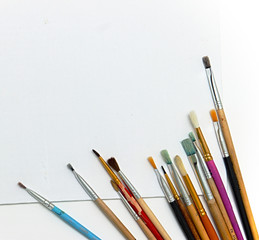 Fototapeta premium Paints and brushes on white canvas background