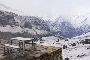 No people lonely Seats and table in serene Scenery of snow falling at Himalaya Annapurna mountain base camp, Nepal