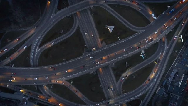 Vertical top down aerial view of traffic on freeway interchange at night