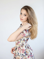 Portrait of a beautiful smiling happy girl  with blond hair in a white dress