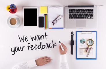 Business Concept: Businessman writing the words WE WANT YOUR FEEDBACK