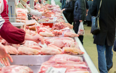 The meat Department at the market. Buyers and sellers in the market. Raw pork.