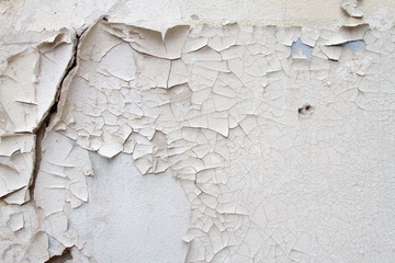 Vintage background texture of old brick masonry on ancient cement with cracks with traces of old paint.