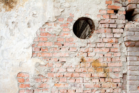 Vintage background texture of old brick masonry on ancient cement with cracks with traces of old paint. © ramann1975