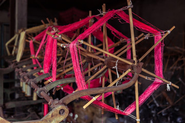 Pink thread on bobbin prepared for weaving and making clothes.