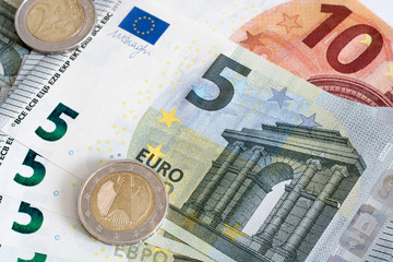  Euro banknotes and coins lie on top of each other