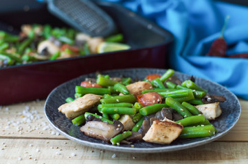 Portion of healthy mix: baked chicken meat, mushrooms, green beans, cherry tomatoes and sesame seeds