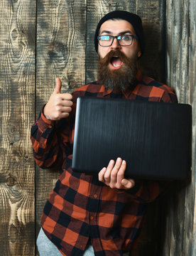Bearded brutal caucasian hipster holding laptop