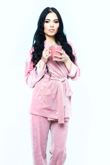 sexy girl in pink velour pajama home suit with cup
