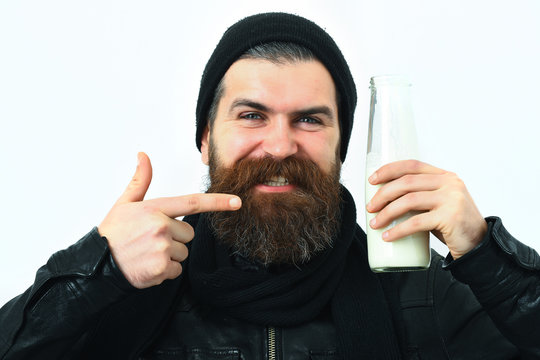 Bearded brutal caucasian hipster holding glass jar of milk