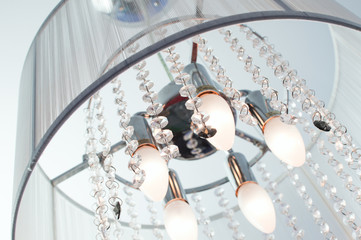 Often, the inclusion chandeliers with crystals and fabric lampshade on the ceiling