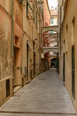 Fototapeta na wymiar narrow alley in sea village, Finale Ligure, Italy