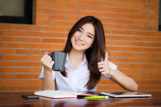 Portrait of thai adult student university uniform beautiful drinking coffee