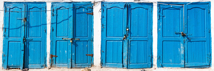 Blue rustic old door in fishing storages in Essauoira fishing port, Morocco