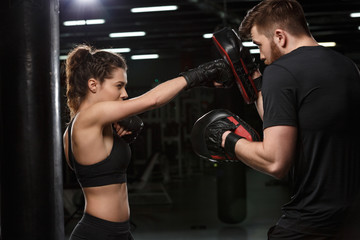 Concentrated young strong sports lady boxer make exercises