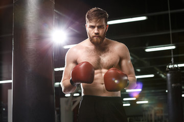 Fototapeta na wymiar Serious handsome young strong sports man boxer