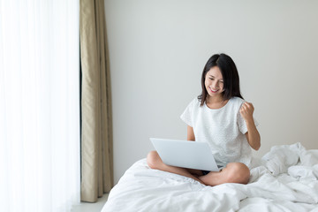 Excited woman working on notebook computer