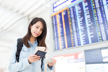 Fototapeta premium Young woman checking her flight on cellphone