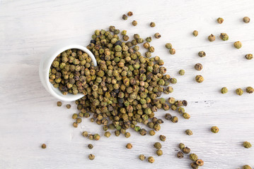 Pepe verde - green peppercorns - on white wooden table. Top view.