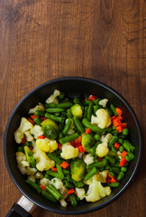 Mixed vegetables in a frying pan. on wood table with copy space. top view