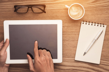 Hands using mobile phone and digital tablet with coffee mug top view shot.