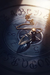 Crystal pendulum on a board
