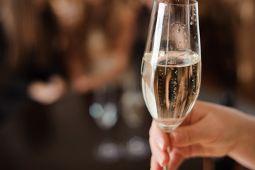 glass of champagne on the background of friends at a party