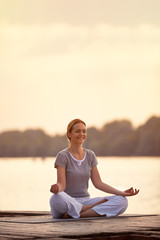 Female person on river in yoga pose