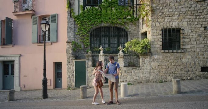 Tourist couple reading City Map planning European holiday In Paris Summer Vacation having disagreement fighting over directions