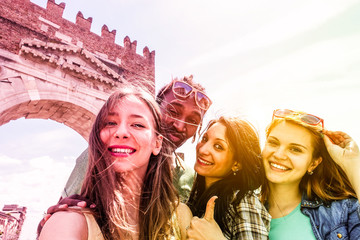 Happy diverse culture friends taking selfie outdoors in italian old town