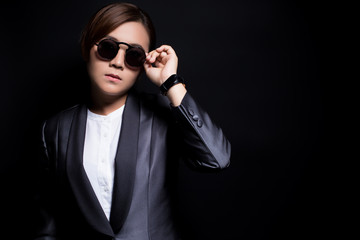 Seriously businesswoman wearing sun glasses on isolated background