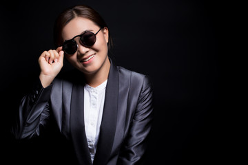 Fototapeta na wymiar Happy businesswoman wearing sun glasses on isolated background