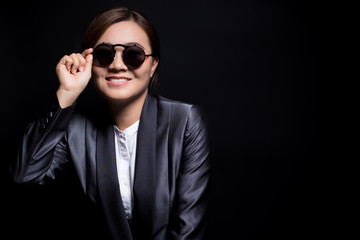 Happy businesswoman wearing sun glasses on isolated background