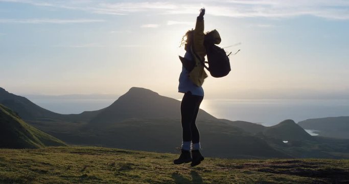 Woman dancing silly freestyle dance at sunset freedom celebration Crazy dancer girl having fun enjoying nature celebrating vacation travel adventure Scotland