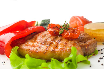 juicy grilled pork with vegetables on a white background, isolated